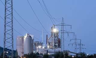 Strommasten stehen im Morgenlicht vor einem Zementwerk: Die Bundesregierung will den Strompreis für die Wirtschaft durch eine Steuerreform drücken senken. - Silas Stein/dpa Strommasten stehen im Morgenlicht vor einem Zementwerk: Die Bundesregierung will den Strompreis für die Wirtschaft durch eine Steuerreform drücken senken. - Silas Stein/dpa