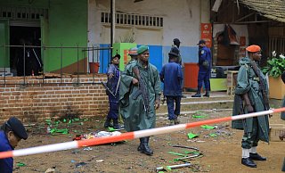 Polizisten inspizieren den Ort einer Bombenexplosion im kongolesischen Beni. - Foto: Al-Hadji Kudra Maliro/AP/dpa Polizisten inspizieren den Ort einer Bombenexplosion im kongolesischen Beni. - Foto: Al-Hadji Kudra Maliro/AP/dpa