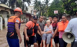 Eine ältere Frau wird von Mitarbeitern der Küstenwache in Sicherheit gebracht. - Uncredited/Philippine Coast Guard/AP/dpa Eine ältere Frau wird von Mitarbeitern der Küstenwache in Sicherheit gebracht. - Uncredited/Philippine Coast Guard/AP/dpa