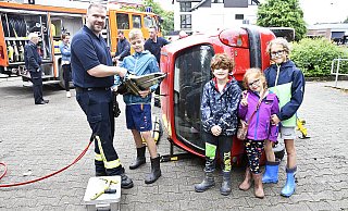 Tobias Koltermann (v.l.) zeigt Finn (12), Kilian (6), Freya (8) und Karl (12) den Umgang mit dem Spreizer, mit dem man zum Beispiel Türen an verunfallten Autos öffnen kann. - Stefanie Boss Tobias Koltermann (v.l.) zeigt Finn (12), Kilian (6), Freya (8) und Karl (12) den Umgang mit dem Spreizer, mit dem man zum Beispiel Türen an verunfallten Autos öffnen kann. - Stefanie Boss