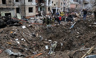Rettungskräfte stehen neben einem Krater in der Nähe beschädigter Wohngebäude nach einem russischen Raketenangriff. - -/Ukrinform/dpa Rettungskräfte stehen neben einem Krater in der Nähe beschädigter Wohngebäude nach einem russischen Raketenangriff. - -/Ukrinform/dpa