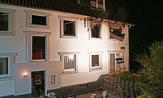 Durch ein Feuer brannte eine Wohnung im ersten Stock dieses Mehrfamilienhauses an der Altenbekener Burgstraße komplett aus. Feuerwehrleute werfen gerade ein Möbelstück aus dem Fenster in den Garten. - Ralph Meyer Durch ein Feuer brannte eine Wohnung im ersten Stock dieses Mehrfamilienhauses an der Altenbekener Burgstraße komplett aus. Feuerwehrleute werfen gerade ein Möbelstück aus dem Fenster in den Garten. - Ralph Meyer
