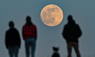Menschen stehen auf einem Hügel und beobachten den aufgehenden Supermond. (Archiv) - dpa Menschen stehen auf einem Hügel und beobachten den aufgehenden Supermond. (Archiv) - dpa