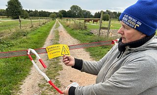 Ein gelbes Hinweisschild warnt vor dem Strom, der durch die Absperrung fließt. - Christian Bröder Ein gelbes Hinweisschild warnt vor dem Strom, der durch die Absperrung fließt. - Christian Bröder