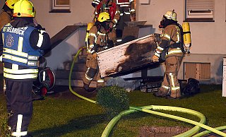 Mannstark: Einsatzkräfte der Delbrücker Feuerwehr tragen an der Brandstelle in der Boker Königsalle den ausgebrannten Gefrierschrank ins Freie. - www.sportpictures.de Mannstark: Einsatzkräfte der Delbrücker Feuerwehr tragen an der Brandstelle in der Boker Königsalle den ausgebrannten Gefrierschrank ins Freie. - www.sportpictures.de