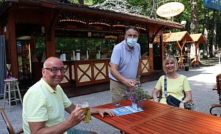 Schausteller Hans-Otto Bröckling (m.) serviert Oliver und Diana Meisehen Bier und Weinschorle bei sommerlichen Temperaturen. - Mareike Gröneweg Schausteller Hans-Otto Bröckling (m.) serviert Oliver und Diana Meisehen Bier und Weinschorle bei sommerlichen Temperaturen. - Mareike Gröneweg
