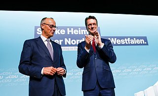 Bundeskanzler Friedrich Merz (l, CDU) steht nach seiner Rede beim Landesparteitag der CDU Nordrhein-Westfalen mit Hendrik Wüst (CDU), Ministerpräsident von Nordrhein-Westfalen, auf der Bühne. - Thomas Banneyer/dpa Bundeskanzler Friedrich Merz (l, CDU) steht nach seiner Rede beim Landesparteitag der CDU Nordrhein-Westfalen mit Hendrik Wüst (CDU), Ministerpräsident von Nordrhein-Westfalen, auf der Bühne. - Thomas Banneyer/dpa