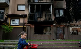 Vor einem zerstörten Gebäude in Irpin nahe Kiew spielt der kleine Yarik mit seinem Spielzeug-Lastwagen. - Foto: Natacha Pisarenko/AP/dpa Vor einem zerstörten Gebäude in Irpin nahe Kiew spielt der kleine Yarik mit seinem Spielzeug-Lastwagen. - Foto: Natacha Pisarenko/AP/dpa