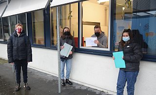 Sebastian Block, Klassenlehrer in der 7c der Realschule Enger, reicht seinen Schülern Michel, Malin und Melody die Halbjahres-Zeugnisse durchs offene Fenster an. - Mareike Patock Sebastian Block, Klassenlehrer in der 7c der Realschule Enger, reicht seinen Schülern Michel, Malin und Melody die Halbjahres-Zeugnisse durchs offene Fenster an. - Mareike Patock