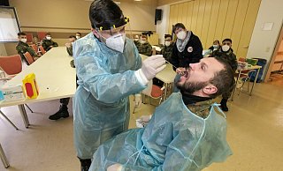 Der Gefreite Roman Spanberger (l.) übt den korrekten Rachenabstrich beim Oberstabsgefreiten Oleg Mast. Petra Dommasch vom DRK und die übrigen Soldaten schauen genau hin, ob das Stäbchen korrekt geführt wird. - Foto: Andreas Zobe/NW Der Gefreite Roman Spanberger (l.) übt den korrekten Rachenabstrich beim Oberstabsgefreiten Oleg Mast. Petra Dommasch vom DRK und die übrigen Soldaten schauen genau hin, ob das Stäbchen korrekt geführt wird. - Foto: Andreas Zobe/NW