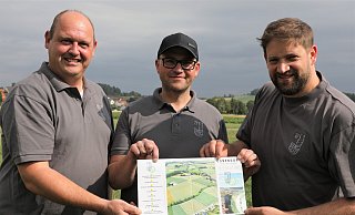 Marc Engemann (v. l.), Wilhelm Engemann und Thomas Fuest vom Festkomitee Ossendorf auf dem Festplatz mit einem Plan, der im Flyer zum Jubiläum enthalten ist. - Simone Flörke Marc Engemann (v. l.), Wilhelm Engemann und Thomas Fuest vom Festkomitee Ossendorf auf dem Festplatz mit einem Plan, der im Flyer zum Jubiläum enthalten ist. - Simone Flörke