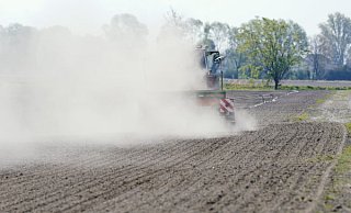 Ein Traktor wirbelt bei der Fahrt über einen Acker Staub auf. Auf vielen Äckern in OWL ist es derzeit staubtrocken. - dpa Ein Traktor wirbelt bei der Fahrt über einen Acker Staub auf. Auf vielen Äckern in OWL ist es derzeit staubtrocken. - dpa