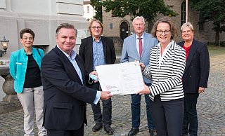 Ministerin Ina Scharrenbach überreicht den Förderbescheid an Bürgermeister Tim Kähler. Mit ihm freuen sich die Gleichstellungsbeauftragte Karola Althoff-Schröder (hi. v. l.), die stellvertretenden Bürgermeister Andreas Rödel und Werner Seeger sowie Birgitt Fischer, Vorsitzende des Kulturbeirates. - Ralf Bittner Ministerin Ina Scharrenbach überreicht den Förderbescheid an Bürgermeister Tim Kähler. Mit ihm freuen sich die Gleichstellungsbeauftragte Karola Althoff-Schröder (hi. v. l.), die stellvertretenden Bürgermeister Andreas Rödel und Werner Seeger sowie Birgitt Fischer, Vorsitzende des Kulturbeirates. - Ralf Bittner