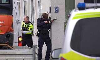 Dieses Bild kursiert in sozialen Medien: Der Polizist zielt um die Ecke, jedoch fehlt das Magazin seiner Waffe. Dafür gibt es jedoch eine Erklärung. - Christian Müller/TV7news/dpa Dieses Bild kursiert in sozialen Medien: Der Polizist zielt um die Ecke, jedoch fehlt das Magazin seiner Waffe. Dafür gibt es jedoch eine Erklärung. - Christian Müller/TV7news/dpa