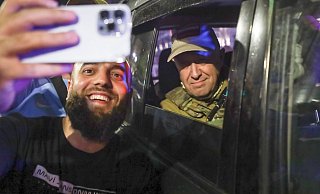 Jewgeni Prigoschin (r), Eigentümer des Militärunternehmens Wagner Group, sitzt in einem Militärfahrzeug und lässt ein Selfie mit einem Zivilisten auf einer Straße in Rostow am Don machen. - -/AP/dpa Jewgeni Prigoschin (r), Eigentümer des Militärunternehmens Wagner Group, sitzt in einem Militärfahrzeug und lässt ein Selfie mit einem Zivilisten auf einer Straße in Rostow am Don machen. - -/AP/dpa