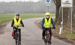 Heike Landwehr (l) und Thomas Karrasch (r) beim Test der neuen Fahrradstraße. Eine große aufgestellte Tafel informiert die Verkehrsteilnehmenden über die neuen Regeln. - ADFC Gütersloh Heike Landwehr (l) und Thomas Karrasch (r) beim Test der neuen Fahrradstraße. Eine große aufgestellte Tafel informiert die Verkehrsteilnehmenden über die neuen Regeln. - ADFC Gütersloh