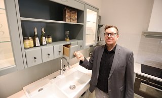 Tristan Beeck zeigt die "Romantik"-Küche im neuen Grünton Eukalyptus - sie hat wie früher Holzschütten integriert. - Nicole Sielermann Tristan Beeck zeigt die "Romantik"-Küche im neuen Grünton Eukalyptus - sie hat wie früher Holzschütten integriert. - Nicole Sielermann