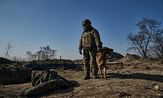 Ein ukrainischer Soldat steht mit seinem Hund an einem Graben in Bachmut. - Libkos/AP/dpa Ein ukrainischer Soldat steht mit seinem Hund an einem Graben in Bachmut. - Libkos/AP/dpa