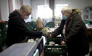 Helfer Günter Niemann gibt Lebensmittel an Sylvia Lehmann aus. - Felix Eisele Helfer Günter Niemann gibt Lebensmittel an Sylvia Lehmann aus. - Felix Eisele