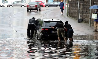 Drei Männer schieben ihren liegen gebliebenen Wagen aus dem tiefen Wasser. - Wolfgang Rudolf Drei Männer schieben ihren liegen gebliebenen Wagen aus dem tiefen Wasser. - Wolfgang Rudolf