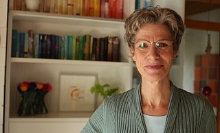 Ordnungsexpertin Ulrike Pieper steht vor ihrem Bücherregal, welches sie nach Farben sortiert hat. - Lena Kley Ordnungsexpertin Ulrike Pieper steht vor ihrem Bücherregal, welches sie nach Farben sortiert hat. - Lena Kley