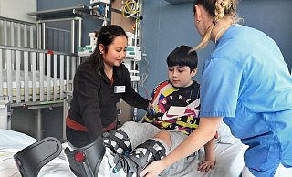 Der zehnjährigen Xandro trägt von einem Lkw-Unfall schwere Beinverletzungen davon. Phoebe Rubia, Chefin des Pflegeteams, (l.) hilft ihm in seinem neuen Zimmer ins Bett. - Barbara Franke Der zehnjährigen Xandro trägt von einem Lkw-Unfall schwere Beinverletzungen davon. Phoebe Rubia, Chefin des Pflegeteams, (l.) hilft ihm in seinem neuen Zimmer ins Bett. - Barbara Franke