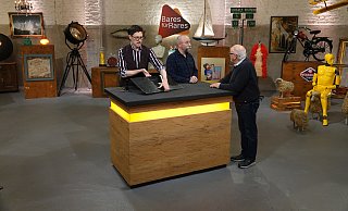 Experte Colmar Schulte-Goltz (v.l.) begutachtet bei "Bares für Rares" das Miele-Emailleschild, während Moderator Horst Lichter mit dem Harsewinkeler Georg Terlutter redet. - ZDF/Warner Experte Colmar Schulte-Goltz (v.l.) begutachtet bei "Bares für Rares" das Miele-Emailleschild, während Moderator Horst Lichter mit dem Harsewinkeler Georg Terlutter redet. - ZDF/Warner