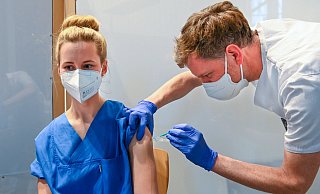 Krankenpfleger Rainer Kleßmann injiziert Vanessa Bahra, die auf der Covid-Intensivstation des EvKB arbeitet, den Impfstoff. - Bethel/ Christian Weische Krankenpfleger Rainer Kleßmann injiziert Vanessa Bahra, die auf der Covid-Intensivstation des EvKB arbeitet, den Impfstoff. - Bethel/ Christian Weische