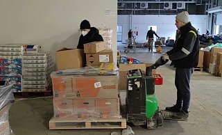 Mit elektrisch betriebenen Hubwagen werden die Waren aus den Hövelhofer Lkw ausgeladen. Organisator Christian Bökamp (l.) hat die Abläufe im Blick. In Polen werden alle Hilfsgüter und Organisationen registriert. - Raphael Athens Mit elektrisch betriebenen Hubwagen werden die Waren aus den Hövelhofer Lkw ausgeladen. Organisator Christian Bökamp (l.) hat die Abläufe im Blick. In Polen werden alle Hilfsgüter und Organisationen registriert. - Raphael Athens