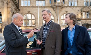 Im Hintergrund der Schlüsselübergabe von Georg Wilsberg (Leonard Lansink, l.) an seinen Freund Manni Höch (Heinrich Schafmeister, Mitte) prangt die Fassade des alten Bielefelder Rathauses. Rechts Kumpel Ekki (Oliver Korittke). - ZDF/Thomas Kost Im Hintergrund der Schlüsselübergabe von Georg Wilsberg (Leonard Lansink, l.) an seinen Freund Manni Höch (Heinrich Schafmeister, Mitte) prangt die Fassade des alten Bielefelder Rathauses. Rechts Kumpel Ekki (Oliver Korittke). - ZDF/Thomas Kost