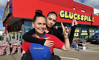 Die mürrische Leonie sitzt huckepack auf dem Rücken von Steffi - beide sind die Gesichter der Burger-Kette Glückspilz, die nun auch in der Kurstadt eröffnet. - Nicole Sielermann Die mürrische Leonie sitzt huckepack auf dem Rücken von Steffi - beide sind die Gesichter der Burger-Kette Glückspilz, die nun auch in der Kurstadt eröffnet. - Nicole Sielermann