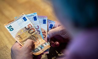 Ein älterer Mann sitzt an einem Tisch und zählt Geld. - Lino Mirgeler/dpa Ein älterer Mann sitzt an einem Tisch und zählt Geld. - Lino Mirgeler/dpa