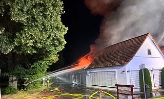 Feuerwehrleute bekämpfen die Flammen, die immer wieder aus dem Dach der Lagerhalle auflodern. Foto: Thorsten Heß - Thorsten Heß Feuerwehrleute bekämpfen die Flammen, die immer wieder aus dem Dach der Lagerhalle auflodern. Foto: Thorsten Heß - Thorsten Heß