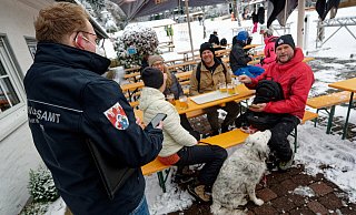 Ein Mitarbeiter des Ordnungsamtes (l.) kontrolliert die Impfzertifikate von Gästen einer Skihütte am Skilift Rauher Busch in Winterberg. - picture alliance/dpa Ein Mitarbeiter des Ordnungsamtes (l.) kontrolliert die Impfzertifikate von Gästen einer Skihütte am Skilift Rauher Busch in Winterberg. - picture alliance/dpa