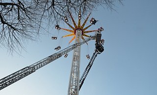 21 Fahrgäste des Kettenkarussells müssen in luftiger Höhe etwa eine Stunde ausharren, bevor die Feuerwehr sie befreien kann. Der Korb der Drehleiter muss 22 Meter ausfahren, um die Fahrgäste zu erreichen. - Ekkehard Hufendiek 21 Fahrgäste des Kettenkarussells müssen in luftiger Höhe etwa eine Stunde ausharren, bevor die Feuerwehr sie befreien kann. Der Korb der Drehleiter muss 22 Meter ausfahren, um die Fahrgäste zu erreichen. - Ekkehard Hufendiek