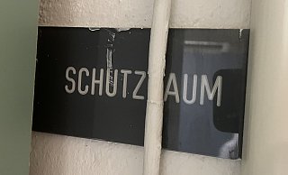Vertseckt in einer Ecke hinter Schränken und einem Rohr ist noch das alte Schild "Schutzraum" zu finden. - Natalie Gottwald Vertseckt in einer Ecke hinter Schränken und einem Rohr ist noch das alte Schild "Schutzraum" zu finden. - Natalie Gottwald