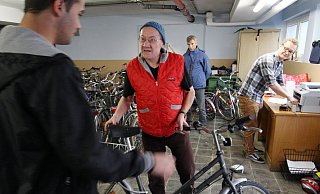 Das passt: Adalbert Grüner (Mitte) übergibt eines der gespendeten Fahrräder an einen jungen Flüchtling. Lukas Grüner (hinten, r.) kümmert sich um die Registrierung. Auf dem Fahrrad sind zwei Aufkleber angebracht: einer vom Verein Non Stop Ultra und einer von der Flüchtlingshilfe. - SIMONE FLÖRKE Das passt: Adalbert Grüner (Mitte) übergibt eines der gespendeten Fahrräder an einen jungen Flüchtling. Lukas Grüner (hinten, r.) kümmert sich um die Registrierung. Auf dem Fahrrad sind zwei Aufkleber angebracht: einer vom Verein Non Stop Ultra und einer von der Flüchtlingshilfe. - SIMONE FLÖRKE