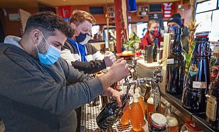 Den Zapfhahn fest im Griff: Amir Nemat (vorne) und Max Meis haben alle Hände voll zu tun. Das Schankbier fließt in verschließbare Flaschen. Die Kundschaft hinter dem Tresen wartet. - Sarah Jonek Den Zapfhahn fest im Griff: Amir Nemat (vorne) und Max Meis haben alle Hände voll zu tun. Das Schankbier fließt in verschließbare Flaschen. Die Kundschaft hinter dem Tresen wartet. - Sarah Jonek