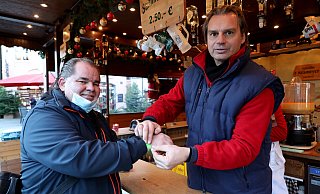 Kunde Jürgen Feyerabend lässt sich das grüne Bändchen von Schausteller Raoul Krameyer gerne anlegen. - Frank-Michael Kiel-Steinkamp Kunde Jürgen Feyerabend lässt sich das grüne Bändchen von Schausteller Raoul Krameyer gerne anlegen. - Frank-Michael Kiel-Steinkamp