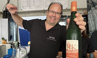 Peter Reichert vom Stand Weinberatung Janine Reichert/Moselwein e.V. zeigt einen Riesling. - Gina Köhler Peter Reichert vom Stand Weinberatung Janine Reichert/Moselwein e.V. zeigt einen Riesling. - Gina Köhler