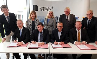 Wichtige Unterschrift: Rainer Norden (Aufsichtsratsvorsitzender des evangelischen Klinikums Bethel, vorne v. l.), Michael Ackermann (Geschäftsführer Klinikum Bielefeld), Gerhard Sagerer (Rektor der Universität Bielefeld) und Johannes Hütte (Geschäftsführer Klinikum Lippe) unterzeichnen die Kooperationsvereinbarung für das Universitätsklinikum OWL. Frank Lohkamp (Geschäftsführer der medizinischen Fakultät, hinten v. l.), Claudia Hornberg (Gründungsdekanin), Isabel Pfeiffer-Poensgen (NRW-Wissenschaftsministerin), Karl-Josef Laumann (NRW-Gesundheitsminister) und Stephan Becker (Kanzler der Universität Bielefeld) schauen ihnen dabei zu. - Wolfgang Rudolf Wichtige Unterschrift: Rainer Norden (Aufsichtsratsvorsitzender des evangelischen Klinikums Bethel, vorne v. l.), Michael Ackermann (Geschäftsführer Klinikum Bielefeld), Gerhard Sagerer (Rektor der Universität Bielefeld) und Johannes Hütte (Geschäftsführer Klinikum Lippe) unterzeichnen die Kooperationsvereinbarung für das Universitätsklinikum OWL. Frank Lohkamp (Geschäftsführer der medizinischen Fakultät, hinten v. l.), Claudia Hornberg (Gründungsdekanin), Isabel Pfeiffer-Poensgen (NRW-Wissenschaftsministerin), Karl-Josef Laumann (NRW-Gesundheitsminister) und Stephan Becker (Kanzler der Universität Bielefeld) schauen ihnen dabei zu. - Wolfgang Rudolf