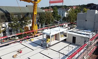 Blick von oben: Die Module für die 39 Wohnungen werden fix und fertig angeliefert und vor Ort zusammengesetzt. - Solidbox Blick von oben: Die Module für die 39 Wohnungen werden fix und fertig angeliefert und vor Ort zusammengesetzt. - Solidbox