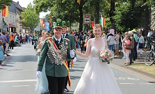 Das amtierende Elsener Schützenkönigspaar Michelle Meier, hier in einem weißen Kleid, und Jan Schlenger freut sich bei der Parade über den Applaus der zahlreichen Besucherinnen und Besucher. - Moritz Jülich Das amtierende Elsener Schützenkönigspaar Michelle Meier, hier in einem weißen Kleid, und Jan Schlenger freut sich bei der Parade über den Applaus der zahlreichen Besucherinnen und Besucher. - Moritz Jülich