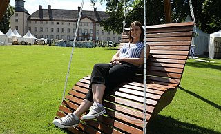 Entspannt: Charmaine Haid vom Veranstalter Evergreen hat Platz genommen auf der bequemen Holzliege eines Anbieters vor dem Schloss Corvey. - Simone Flörke Entspannt: Charmaine Haid vom Veranstalter Evergreen hat Platz genommen auf der bequemen Holzliege eines Anbieters vor dem Schloss Corvey. - Simone Flörke
