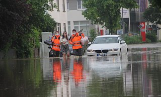 Feuerwehrmänner begleiten eine Frau im Juni 2021 durch das Hochwasser an der Engerstraße. - Florian Weyand (Archivfoto) Feuerwehrmänner begleiten eine Frau im Juni 2021 durch das Hochwasser an der Engerstraße. - Florian Weyand (Archivfoto)