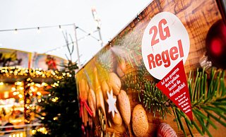 Ein Schild mit der Aufschrift "2G Regel" am Eingang eines Weihnachtsmarkts. - Foto: Hauke-Christian Dittrich/dpa Ein Schild mit der Aufschrift "2G Regel" am Eingang eines Weihnachtsmarkts. - Foto: Hauke-Christian Dittrich/dpa
