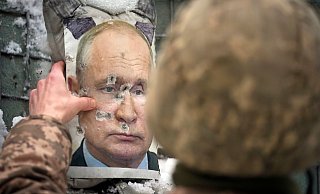 Ein ukrainischer Soldat justiert ein von Kugeln durchlöchertes Bild des russischen Präsidenten Putin. - Foto: Vadim Ghirda/AP/dpa Ein ukrainischer Soldat justiert ein von Kugeln durchlöchertes Bild des russischen Präsidenten Putin. - Foto: Vadim Ghirda/AP/dpa