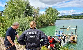 Die Taucher aus Bochum gehen zum Boot und suchen dann zwei Stellen im See ab. - Ilja Regier Die Taucher aus Bochum gehen zum Boot und suchen dann zwei Stellen im See ab. - Ilja Regier