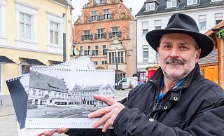 Mathias Polster zeigt den Kalender "Herforder Ansichten 2025" auf dem Neuen Markt. Der ist auch im Kalender zu sehen, allerdings noch mit Autoverkehr. - Ralf Bittner Mathias Polster zeigt den Kalender "Herforder Ansichten 2025" auf dem Neuen Markt. Der ist auch im Kalender zu sehen, allerdings noch mit Autoverkehr. - Ralf Bittner