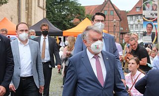 Der NRW-Innenminister, Herbert Reul (Mitte), schreitet mit NRW-Maske und seinen Gastgebern Tim Ostermann (l., Mitglied im Bundestag) und Joachim Ebmeyer (r., Bundestagskandidat) über den Münsterkirchplatz. - Susanne Barth Der NRW-Innenminister, Herbert Reul (Mitte), schreitet mit NRW-Maske und seinen Gastgebern Tim Ostermann (l., Mitglied im Bundestag) und Joachim Ebmeyer (r., Bundestagskandidat) über den Münsterkirchplatz. - Susanne Barth